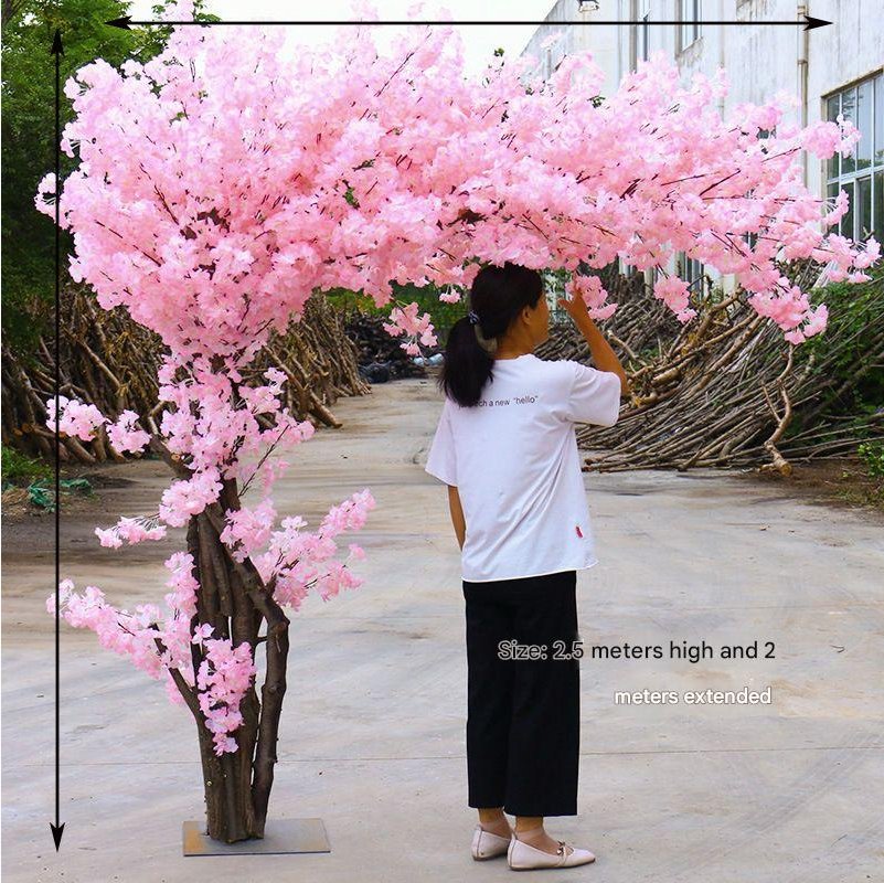 The blossom tree in an indoor reception, flowers spread above the tables