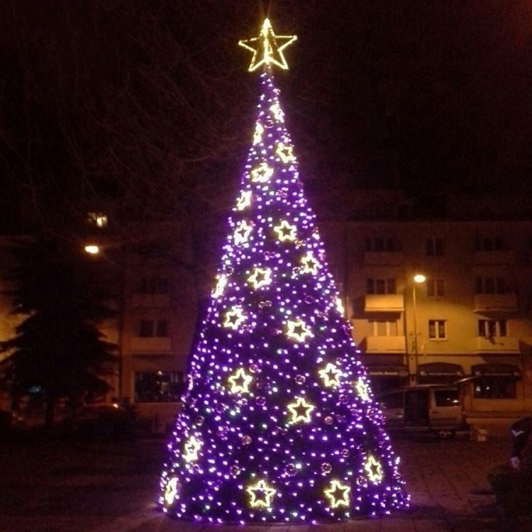 The spruce-style LED Christmas tree lit at night in a shopping centre forecourt display