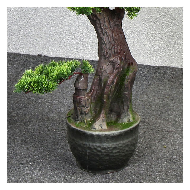 The artificial welcome pine set beside a reception desk in a hotel entrance hall