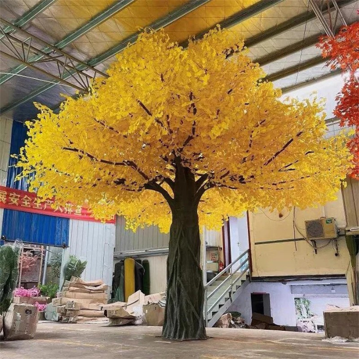 Artificial ginkgo tree with fan-shaped leaves set on a natural wood trunk, for hotel lobbies