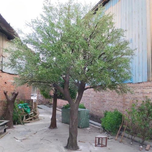 Decorative faux olive tree for outdoor landscaping, silver-green foliage above