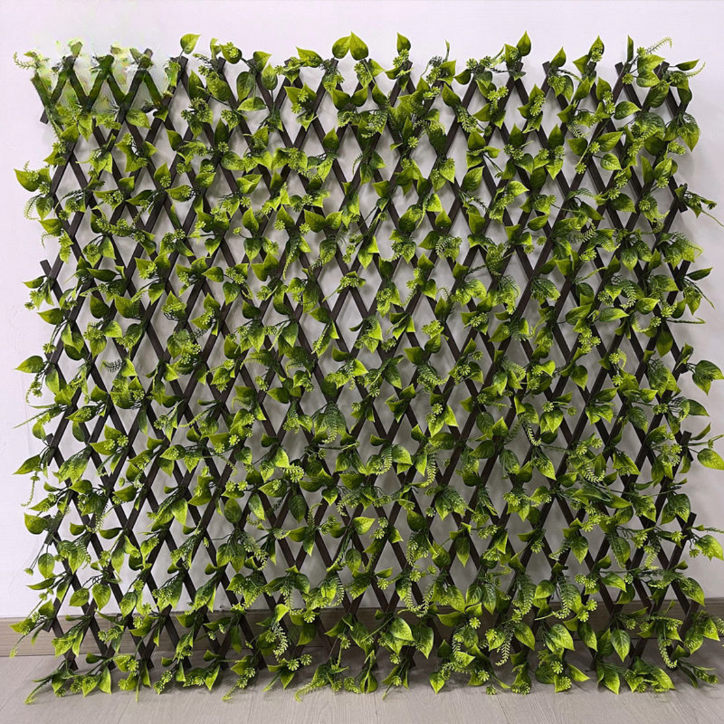 Artificial leaf trellis fence expanded into a green panel of dense PVC plastic foliage