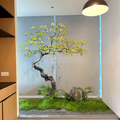 Large artificial spring flower plant, blossom and foliage on a natural wood trunk