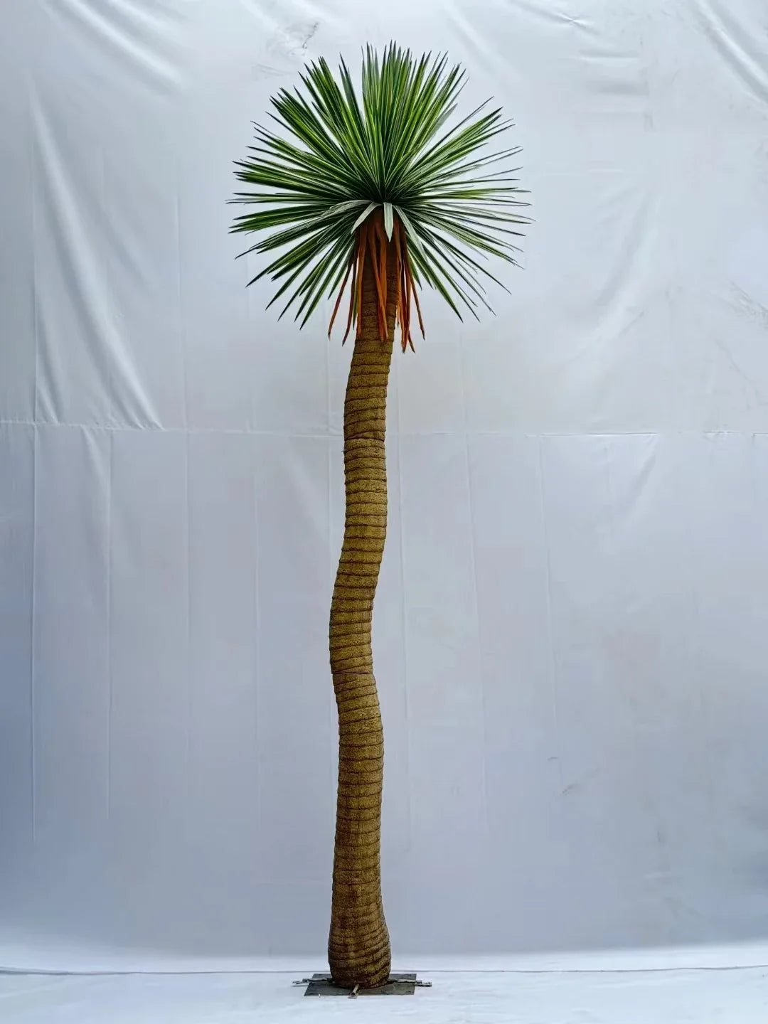 The same tree used outdoors on a patio, standing beside furniture and planters