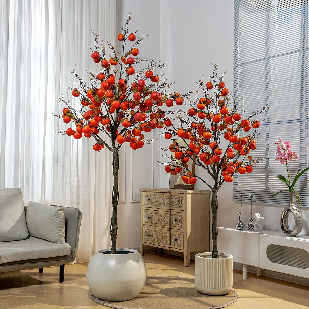 Artificial persimmon tree hung with realistic red fruit among deep green leaves