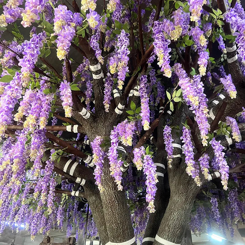 The purple wisteria used as a backdrop behind a wedding ceremony aisle