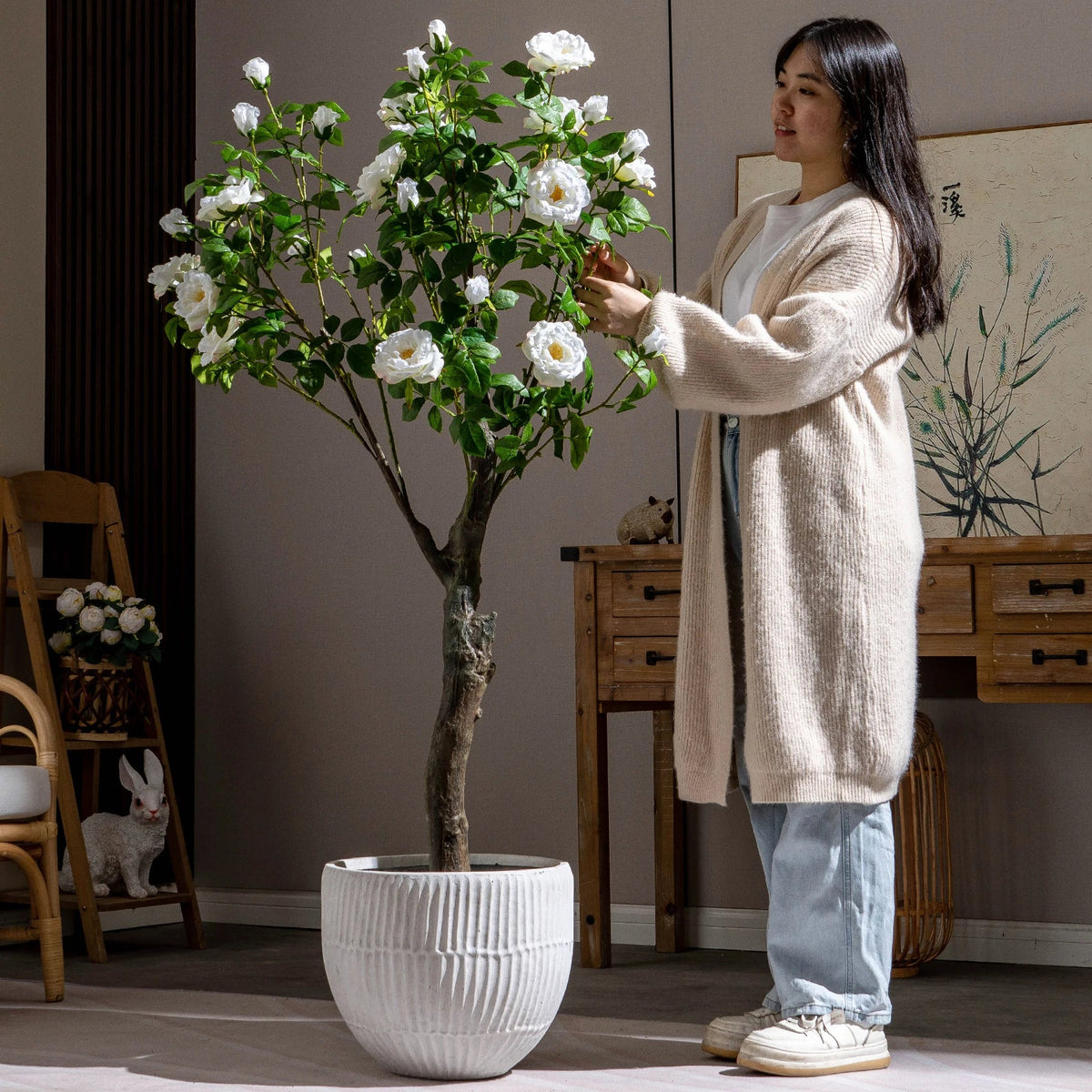 The rose tree in an office reception, pink flowers against a plain wall