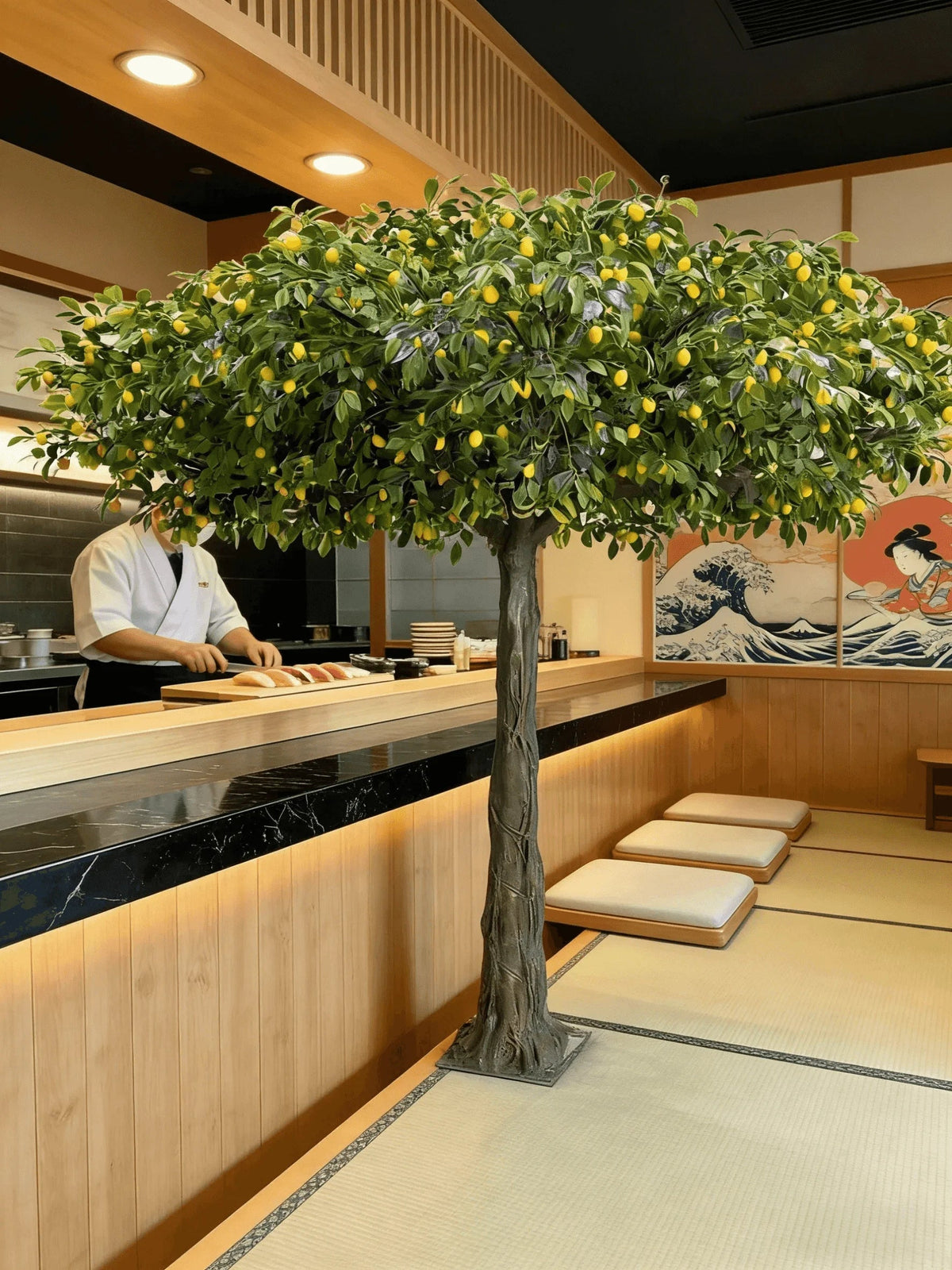 The 6.7ft lemon tree in a hotel lobby standing beside a pale stone wall
