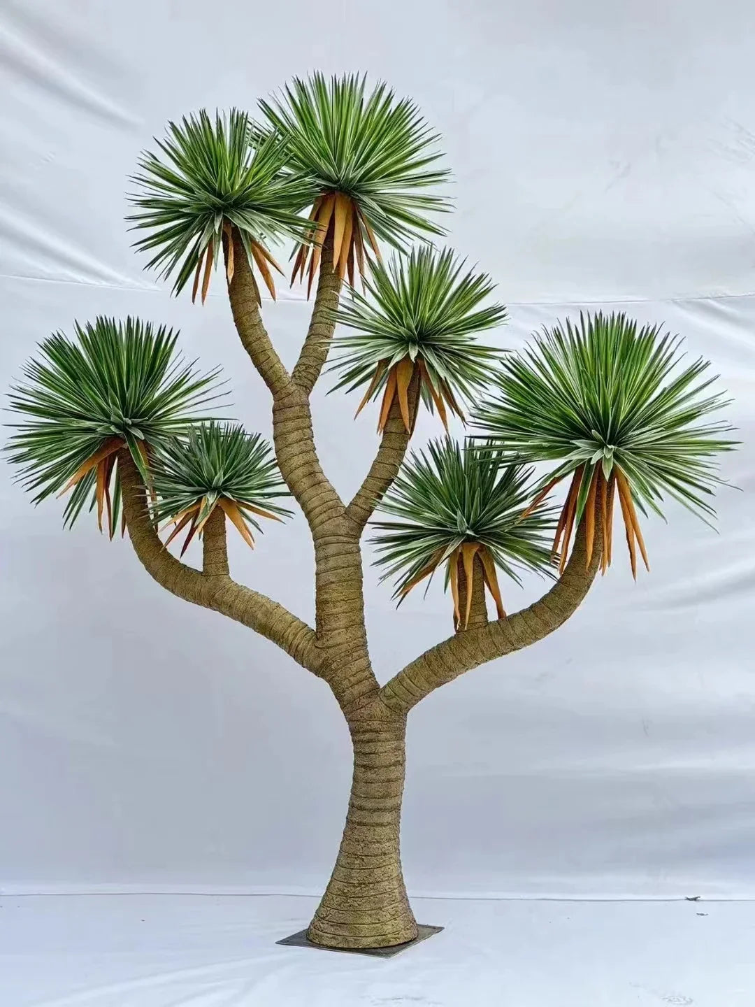 Base of the artificial tree where the trunk sets down into its floor planter