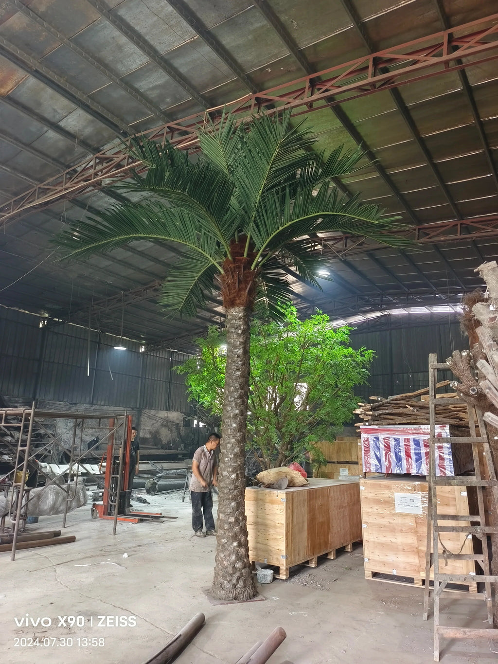 UV-protected artificial coconut palm, tall trunk with broad fronds at the crown