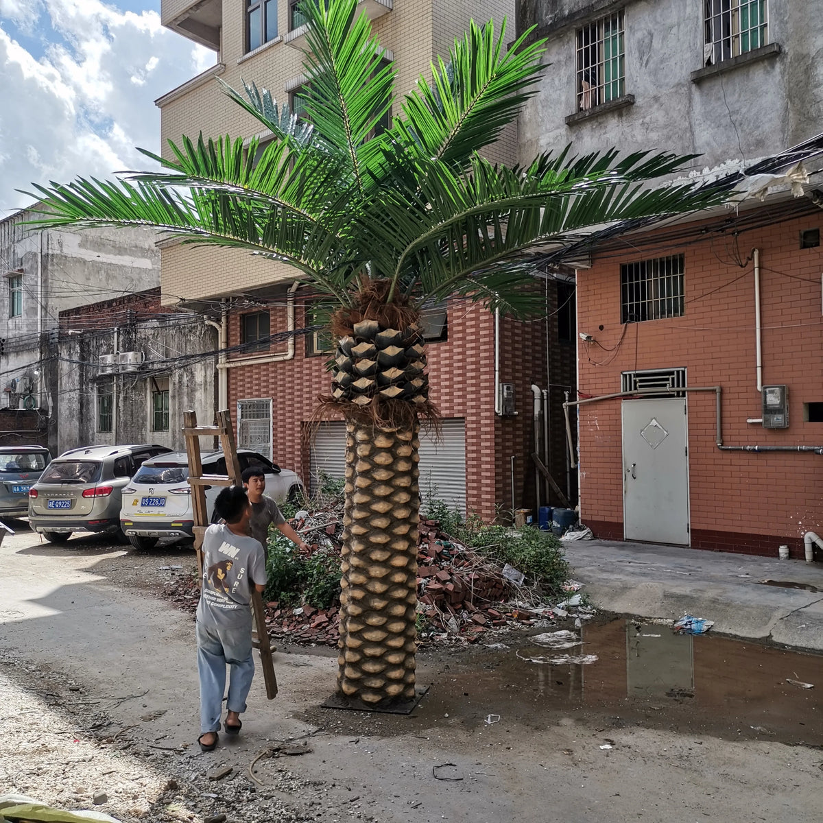 Artificial date palm standing 6m tall, its fronds arching from a thick fibrous trunk