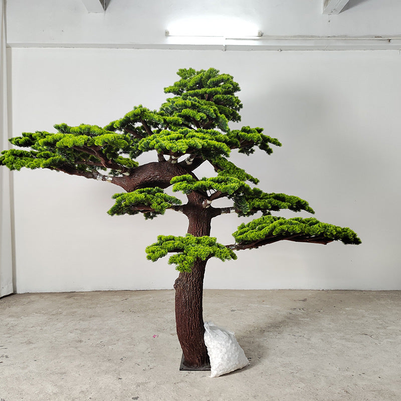 Artificial pine plant with its green needle pads set on a natural wood trunk
