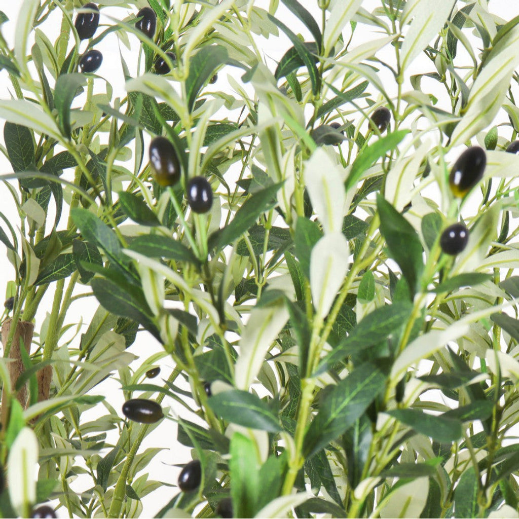 The trunk of the 3m artificial olive tree rising out of its large floor planter