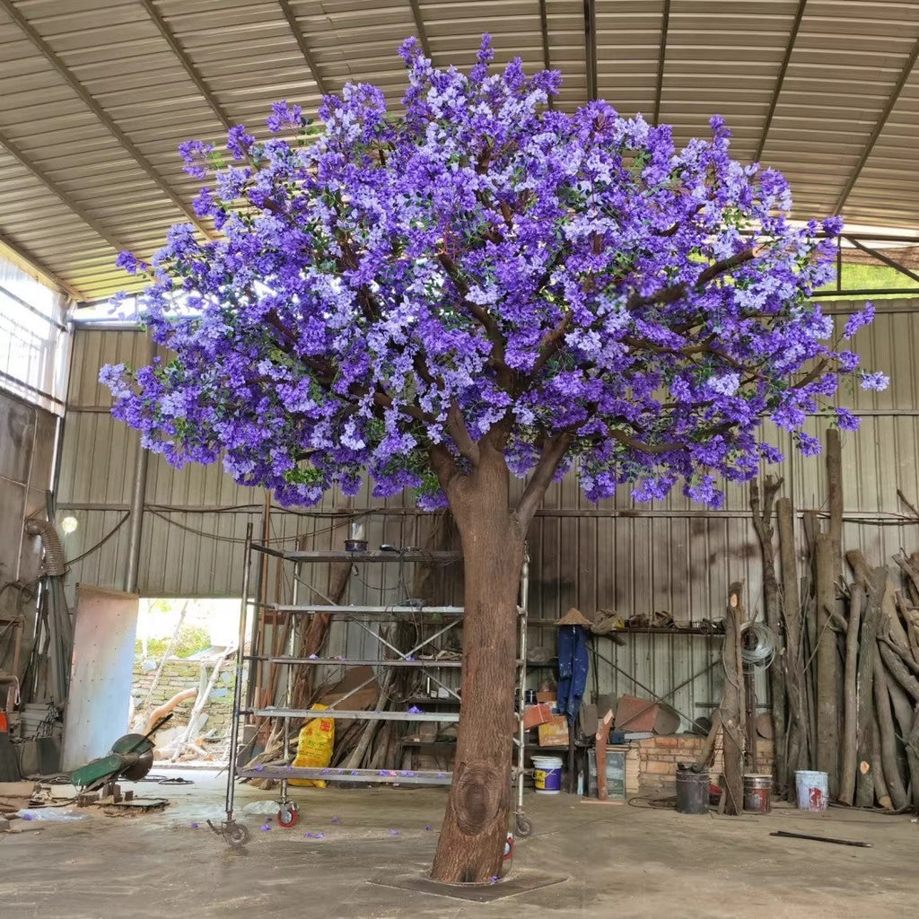 The purple blossom tree used as a backdrop behind a wedding ceremony aisle