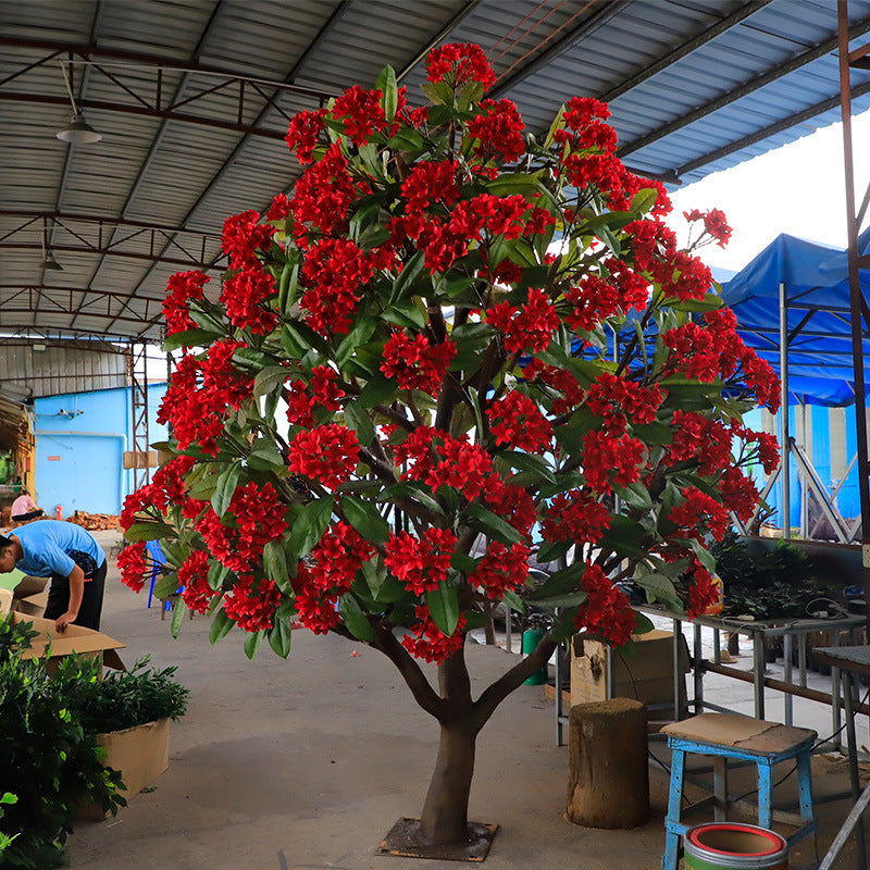 Artificial plumeria tree with silk frangipani flowers among long tapering leaves