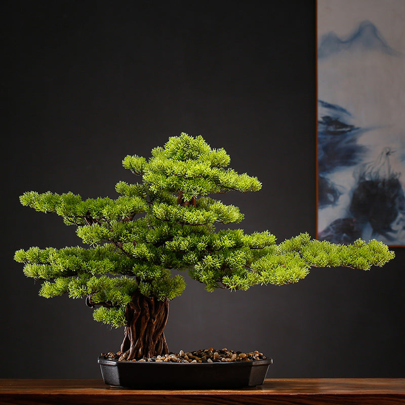 Two of the artificial bonsai trees displayed side by side on a shelf