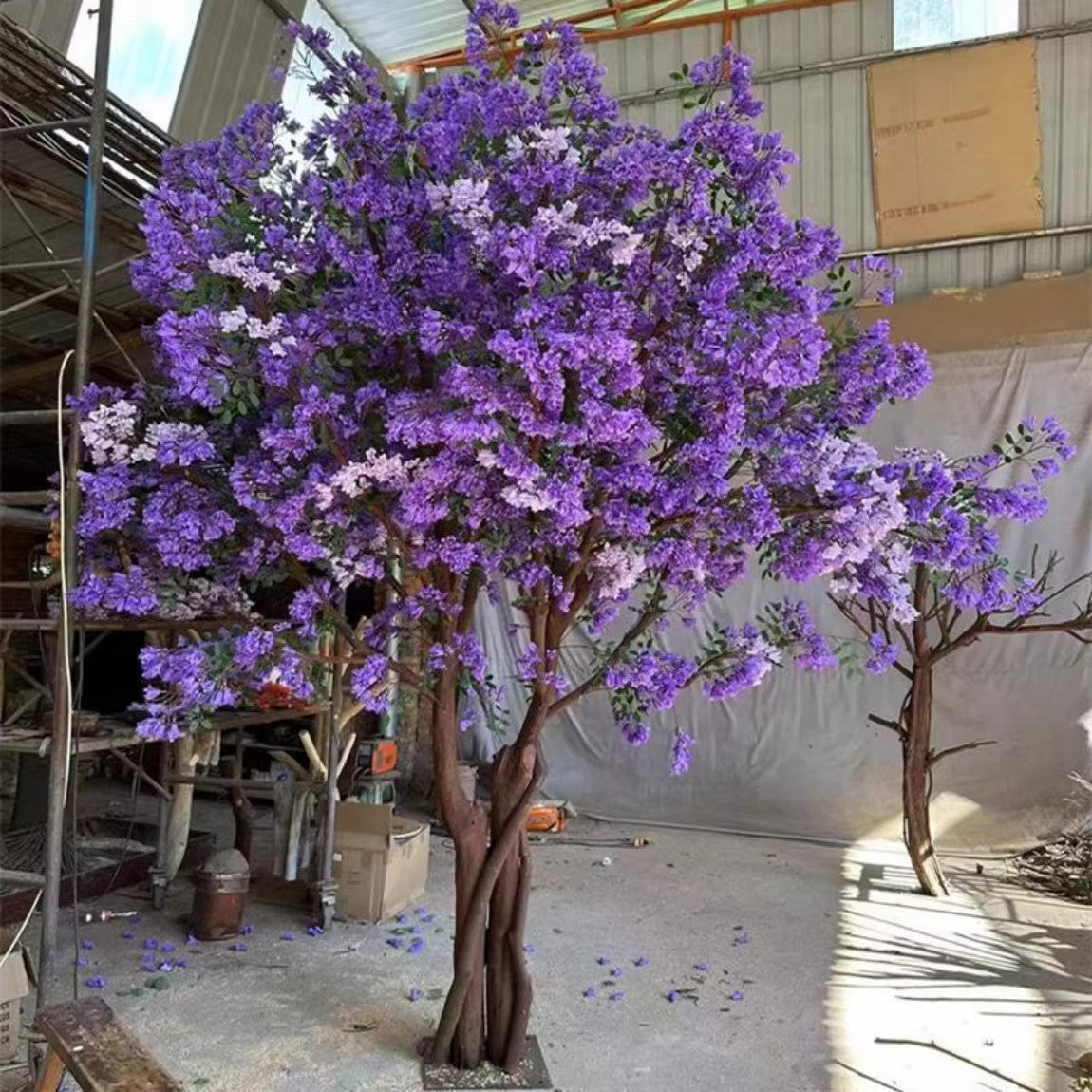 The blossom tree standing in a restaurant interior beside dining tables