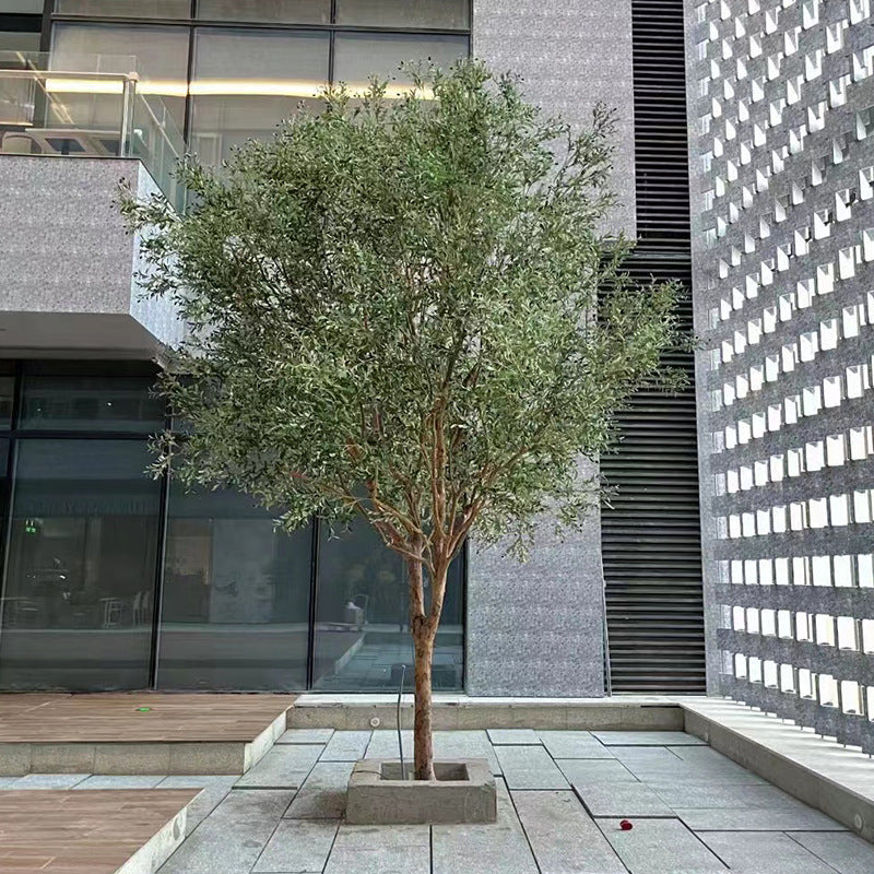 Artificial olive tree with a real wood trunk and dense silver-green foliage above