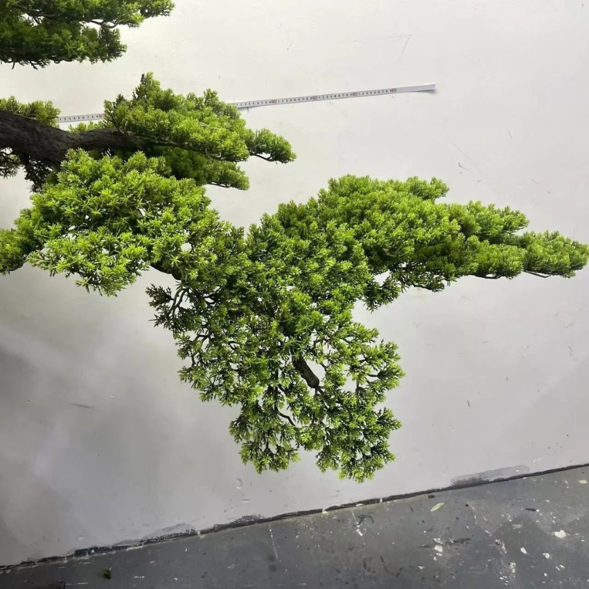 The 6.5ft bonsai pine placed in an office lobby beside a seating group