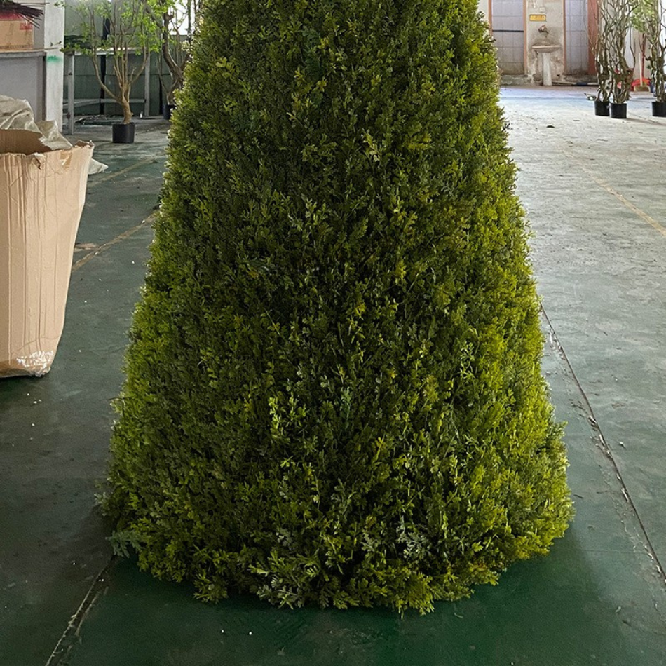 Conical topiaries lining a wedding aisle on either side of the central walkway