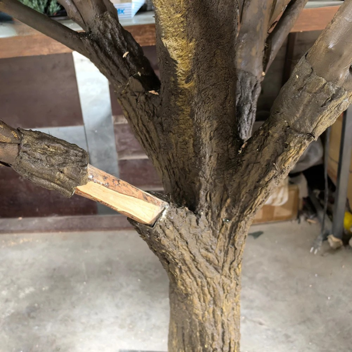 The trunk of the artificial pine rising between its tiers of branches