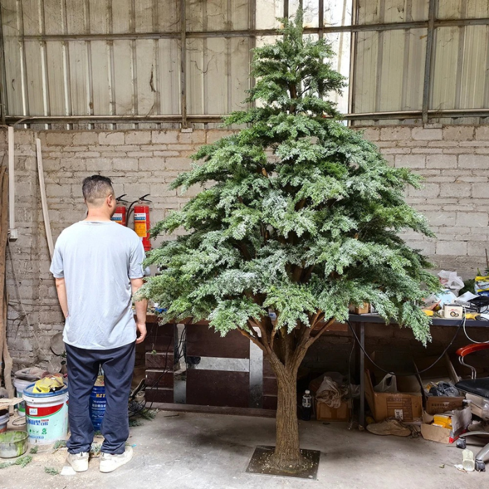 Artificial pine tree with lifelike green needles massed across tiered branches