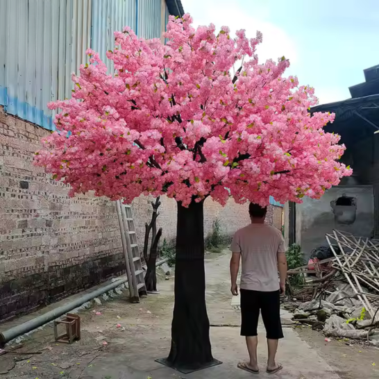 Silk cherry blossom tree with pink flowers massed thickly across bare branches