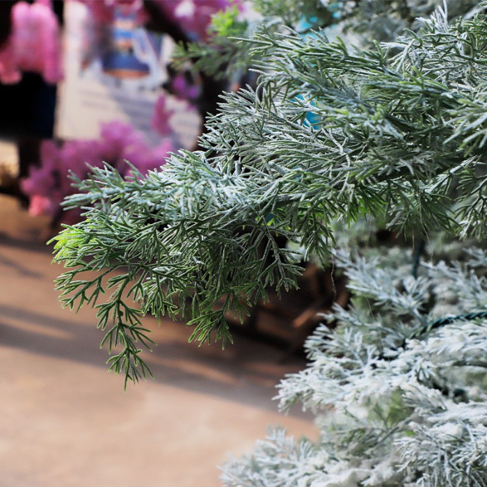 The 6ft flocked cedar standing indoors as a winter holiday display feature