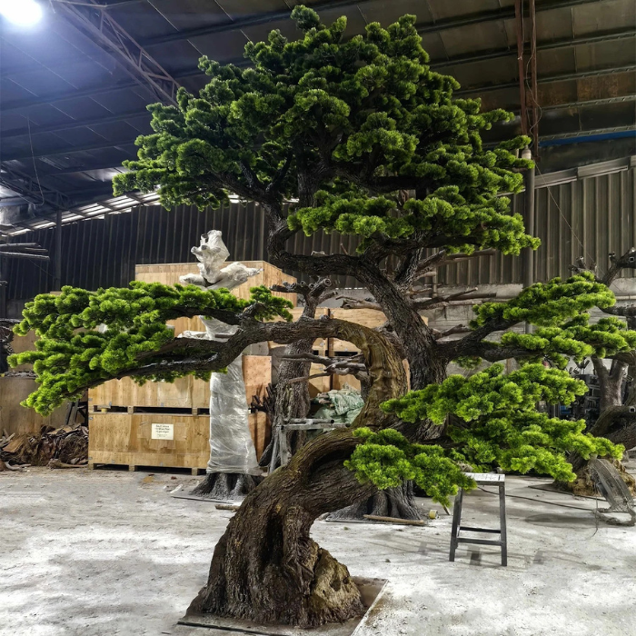 Artificial pine bonsai with lifelike foliage shaped into flat layered pads