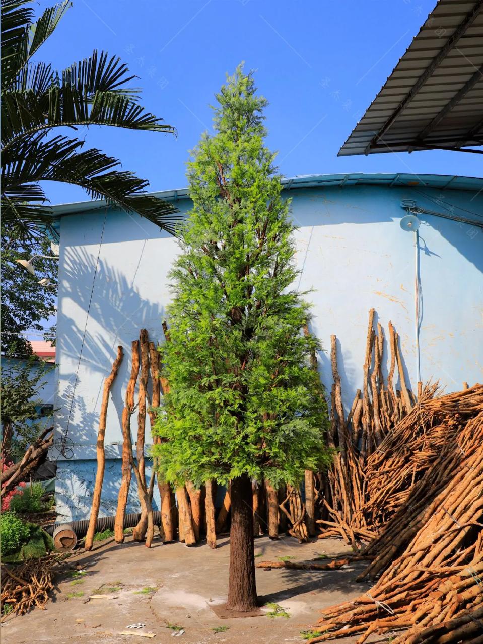 Artificial pine tree 14ft tall, dense green needles across tiered spreading branches