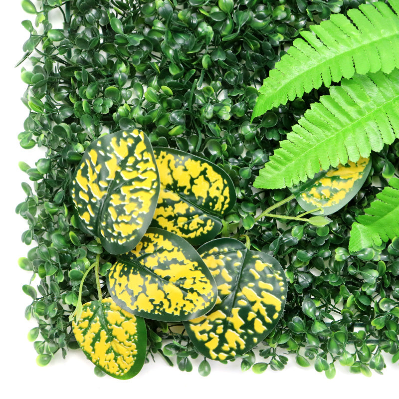 Hedge panels tiled into a full green backdrop wall behind an office lobby desk