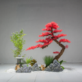 Artificial red maple tree with crimson foliage spreading across an open branch frame