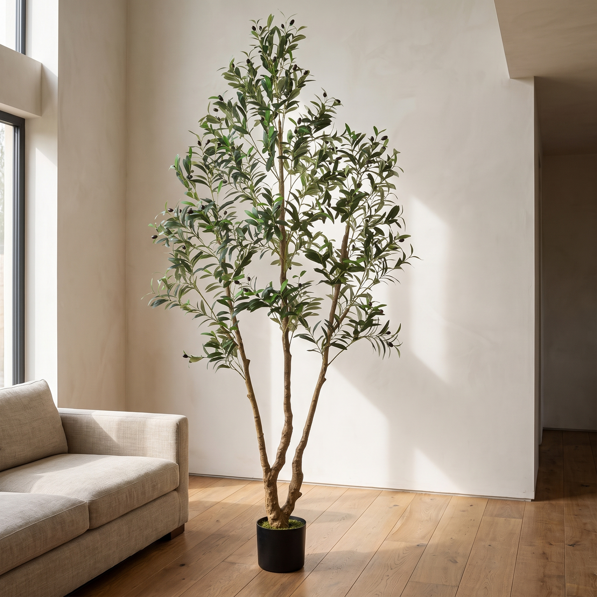 Tall artificial olive tree with rubber silk foliage in a black pot