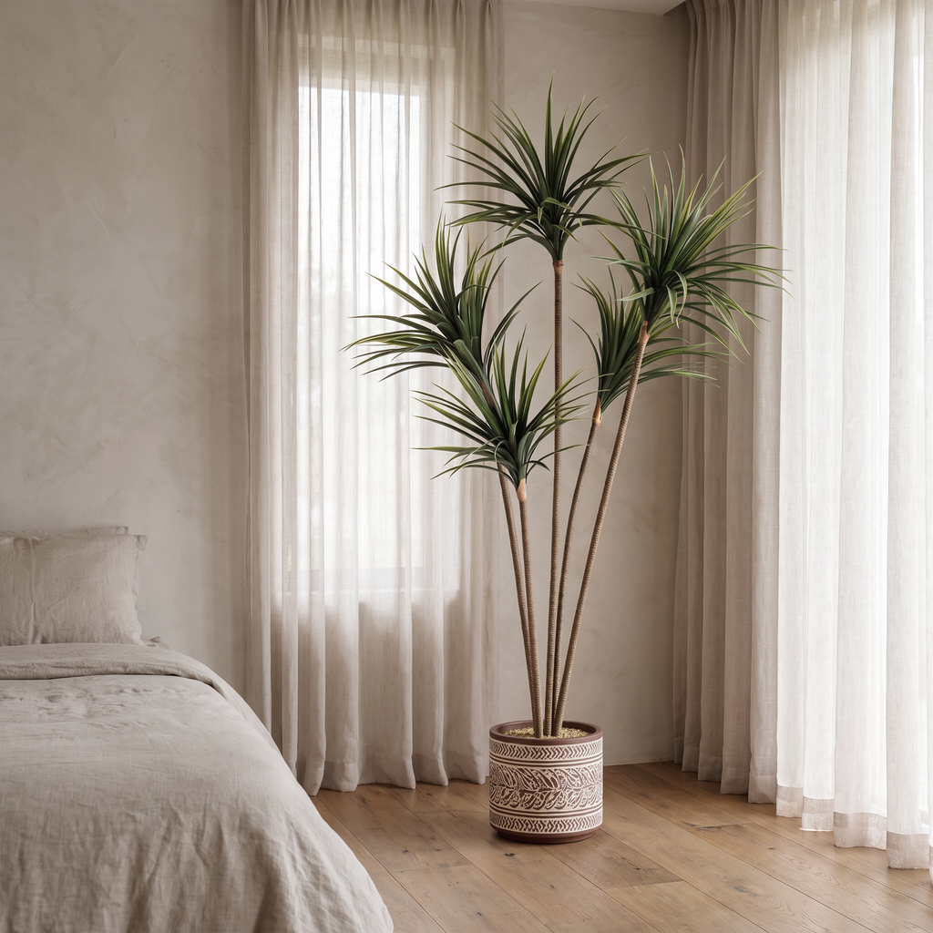Artificial dracaena marginata tree with slender arching leaves on a weighted base