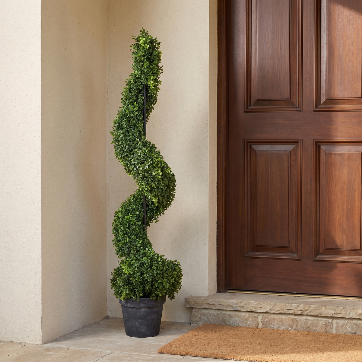 Slender artificial spiral boxwood topiary in a grey pot
