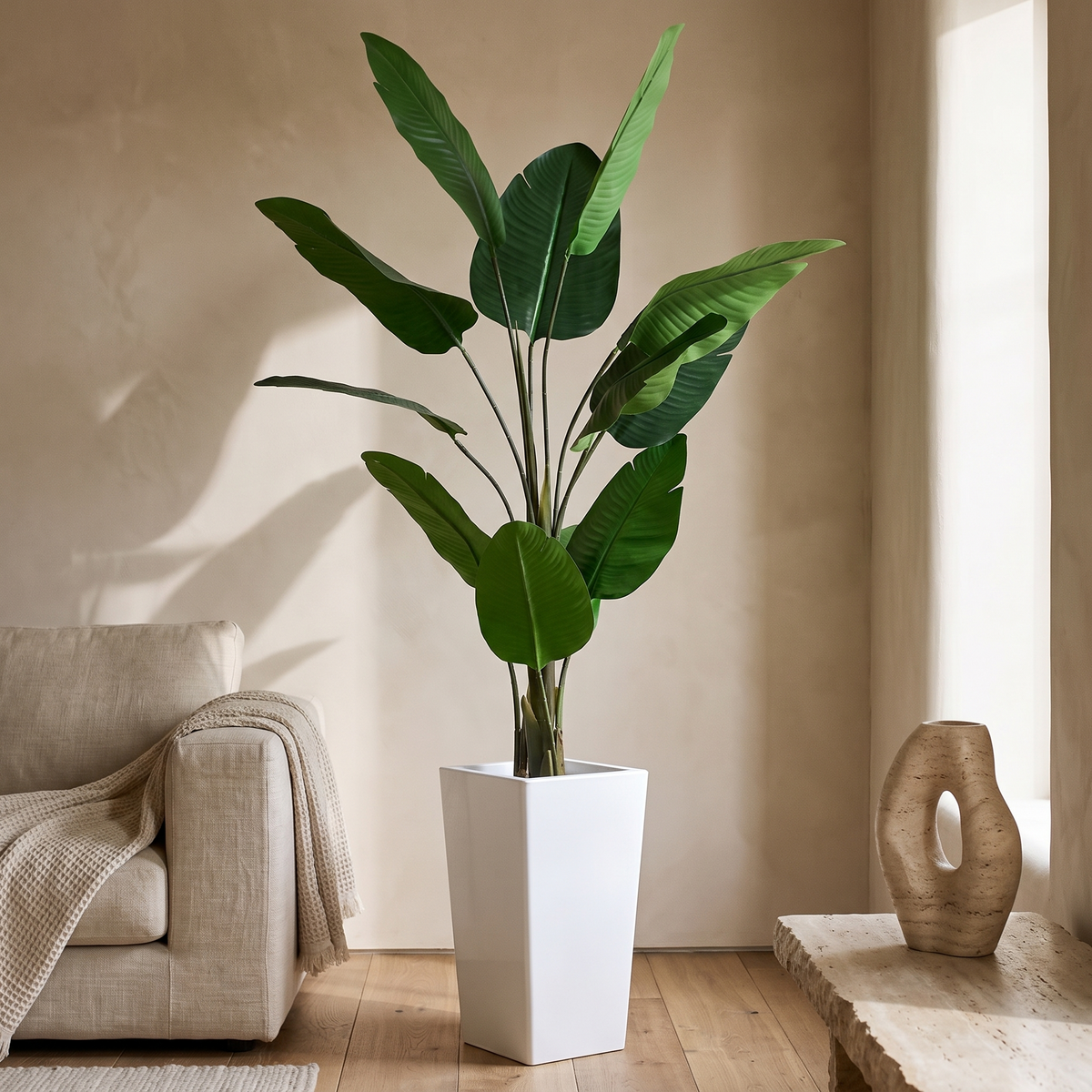 Artificial banana tree in a tall white planter
