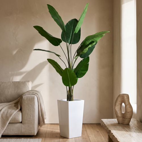 Artificial banana tree in a tall white planter