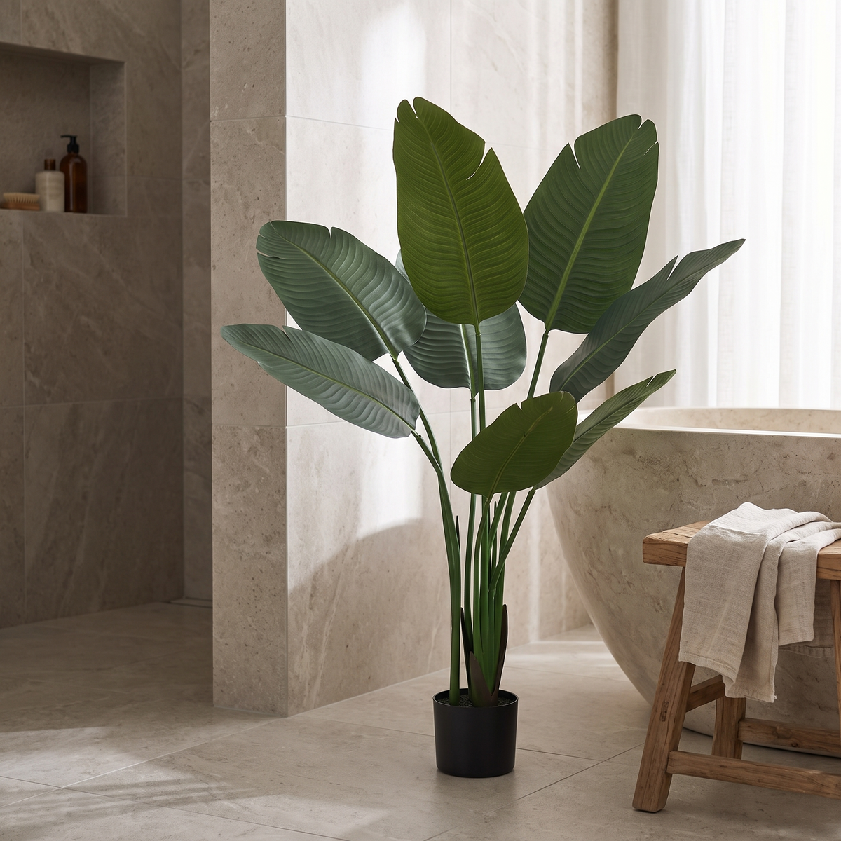 Artificial bird of paradise plant with broad leaves in a black pot