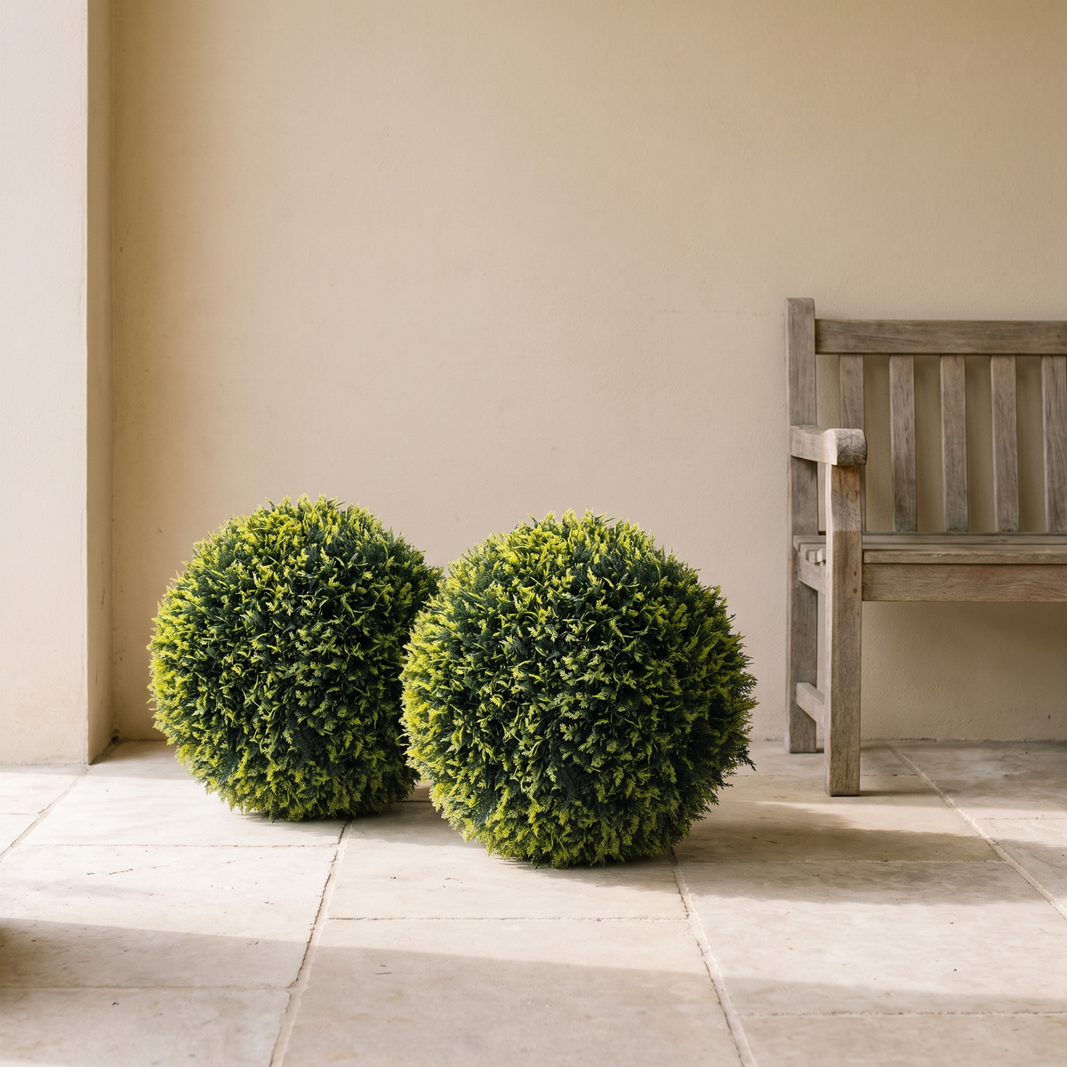 Pair of artificial cedar topiary ball trees in round-clipped form