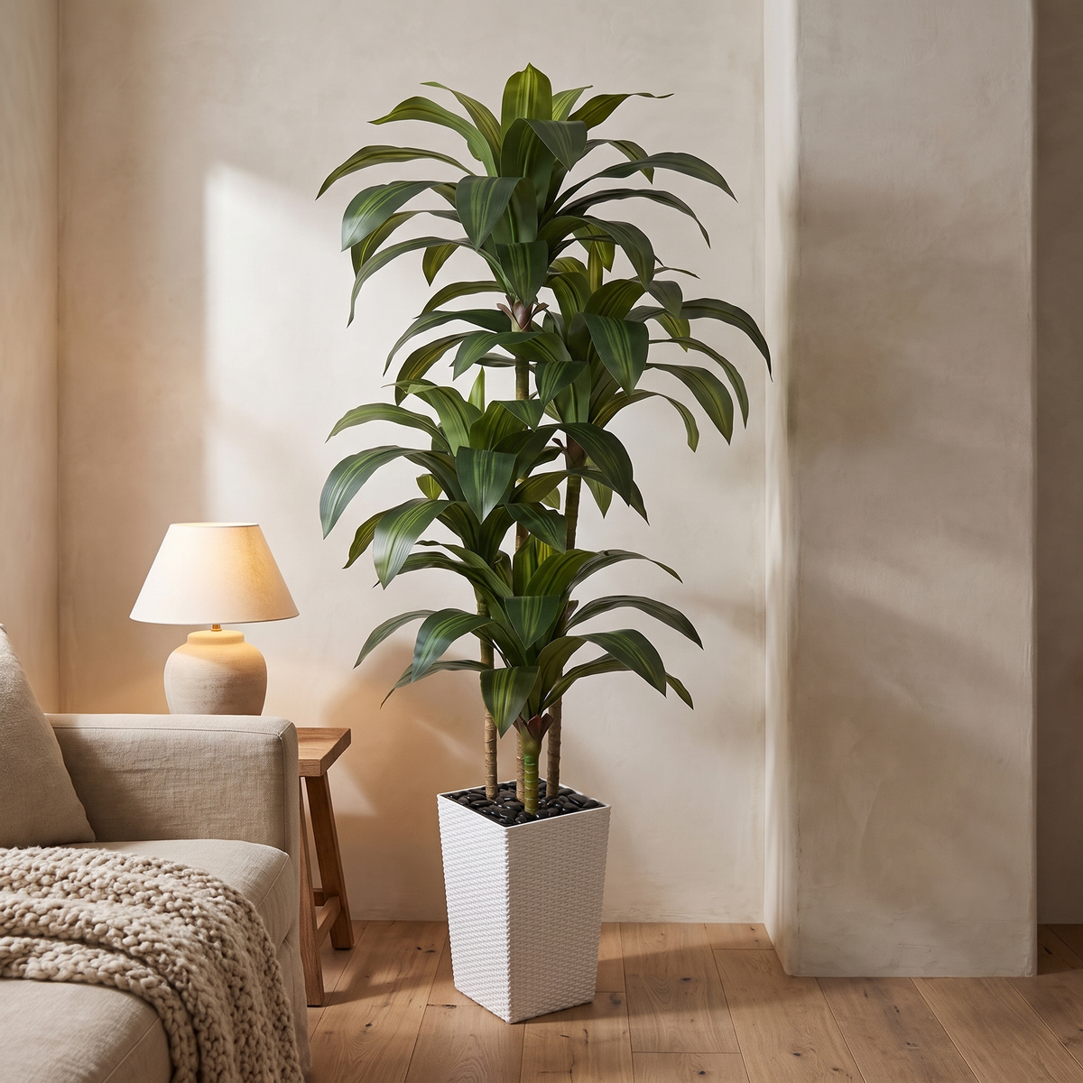Artificial dracaena tree in a tapered planter finished with river rock