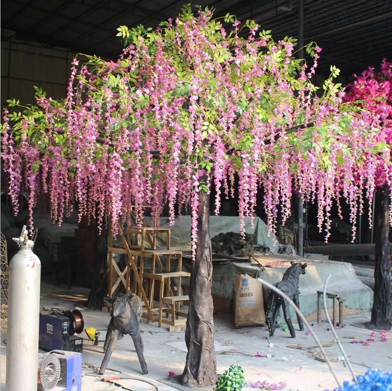 The trunk and branch frame of the wisteria beneath its hanging flowers