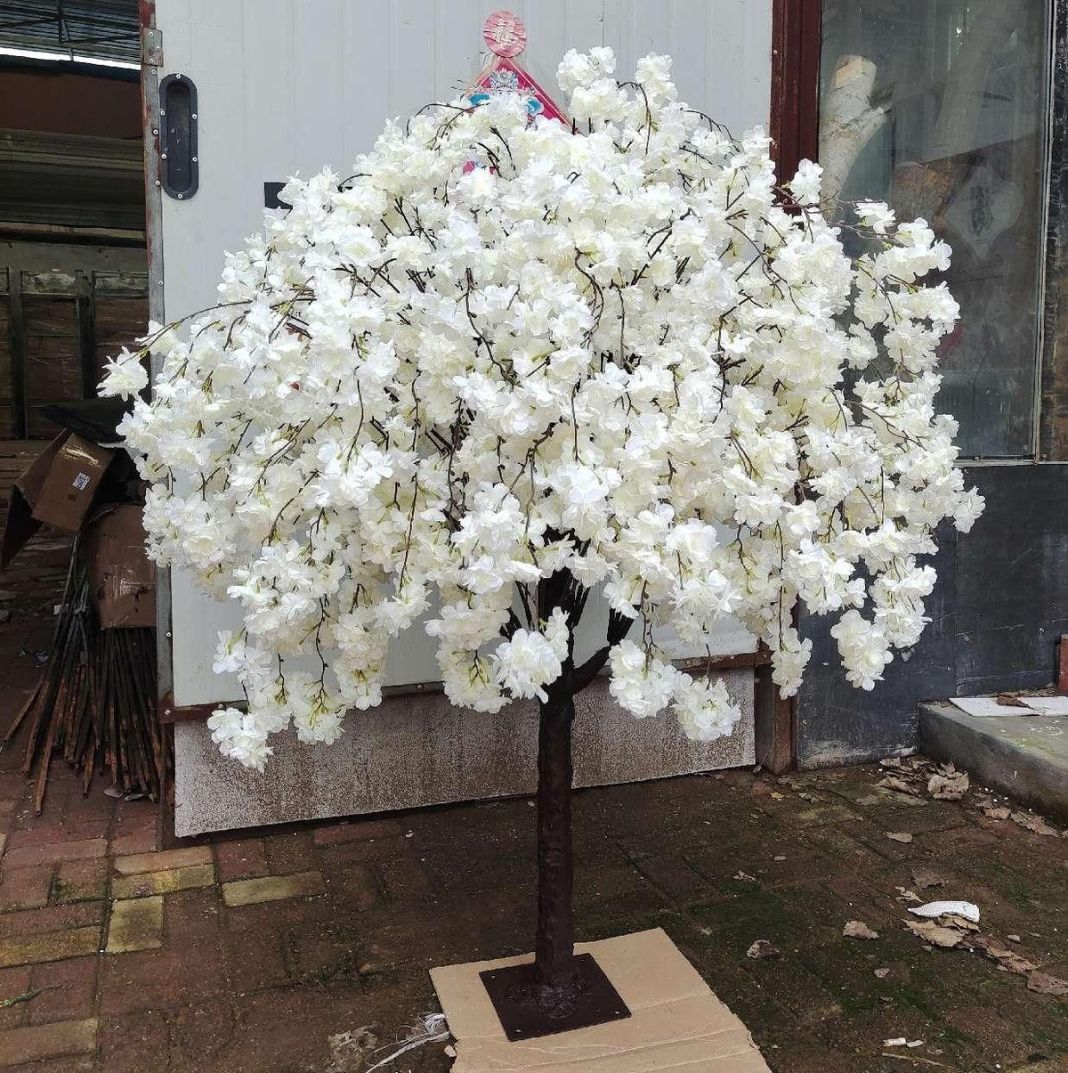 Faux sakura tree with pink blossom massed thickly across bare branching stems